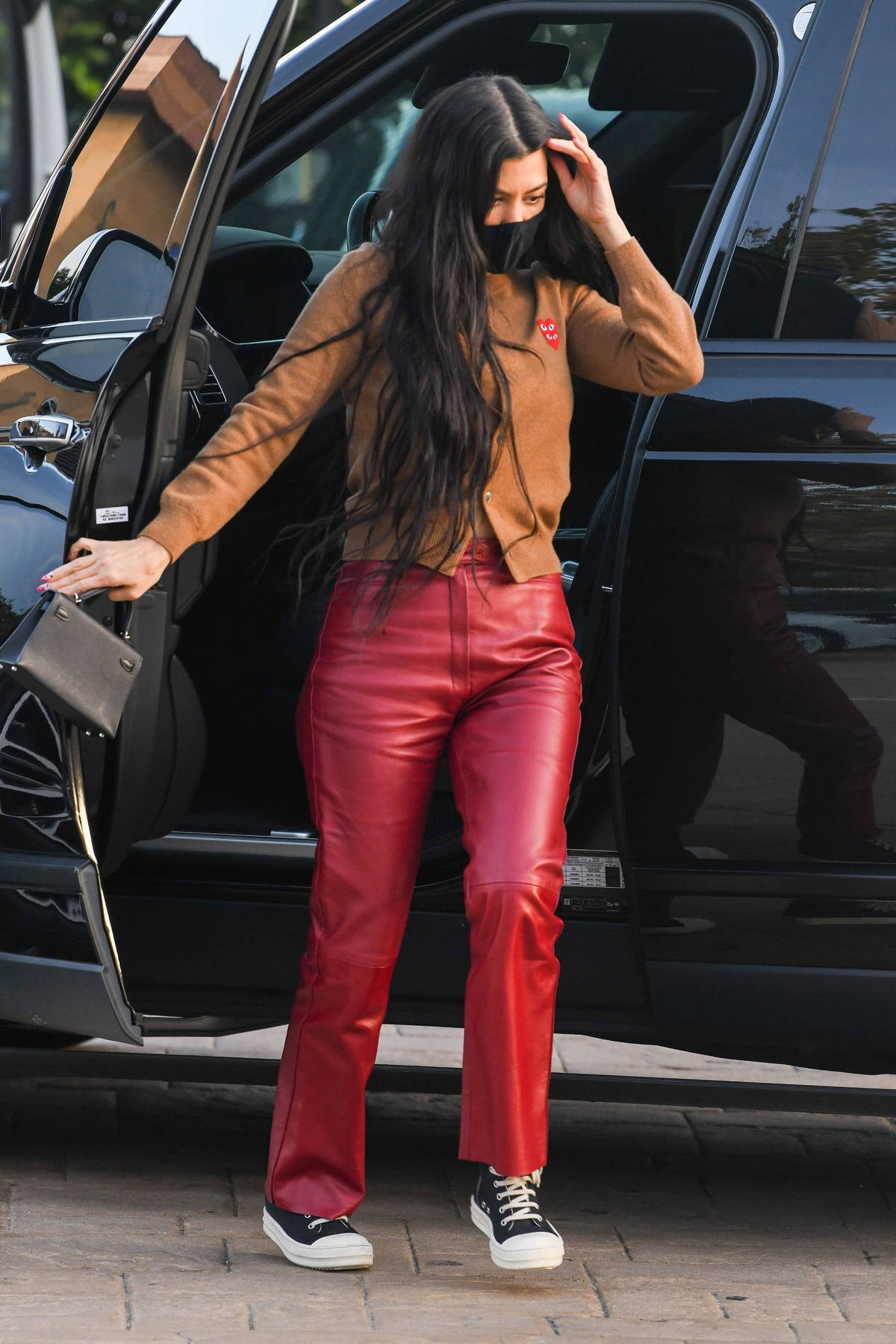 Kourtney Kardashian looks gorgeous in red leather pants and a brown sweater 852444