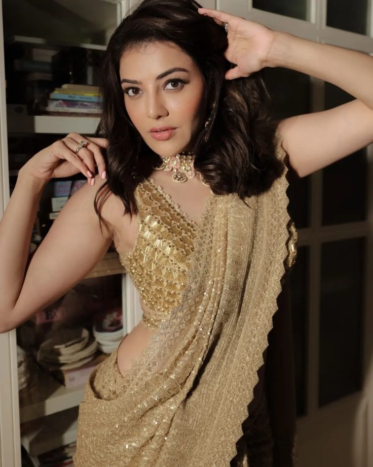 Kajal Aggarwal shines in her heavy embellished gold saree and plunge neck blouse design 853526